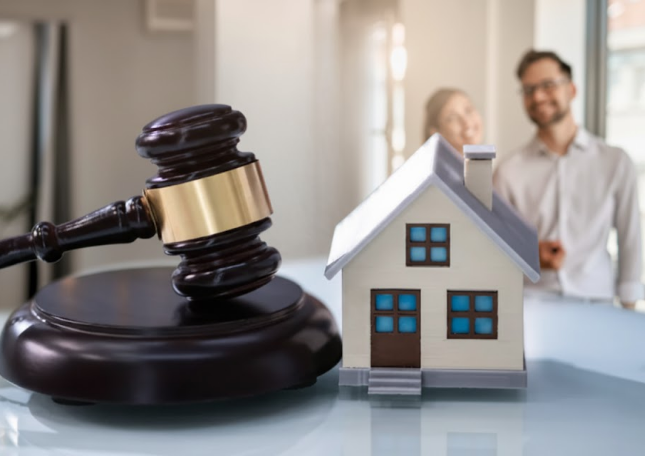 gavel and a house with a couple in the blurred background.